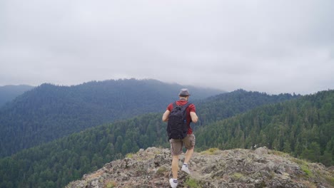 Hombre-Caminando-Sobre-La-Cima-De-Las-Montañas.